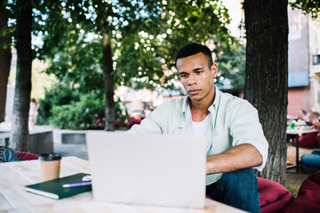 Thoughtful African American male freelancer with laptop