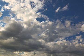 dramatic blue sky with rays and white clouds