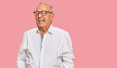 Senior caucasian man wearing business shirt and glasses winking looking at the camera with sexy...