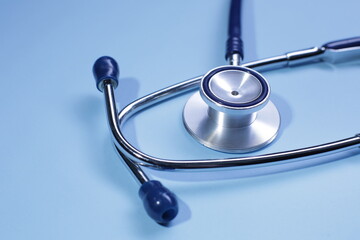 Blue medical stethoscope on blue background. Close-up