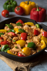 Close up of minced chicken pieces and bell peppers in a pan with use of selective focus.