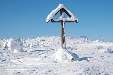 Snowy cross on top of mountain in Lapland Finland