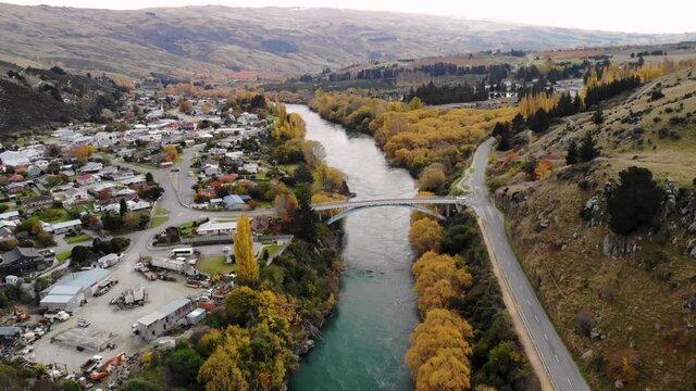 Van crossing the bridge to Roxburgh. Small town beside the river cityscape. New Zealand aerial