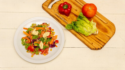 flat lay of a fresh tasty salad on top of a white table	