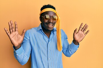 Naklejka premium Handsome black man drunk wearing tie over head and sunglasses celebrating crazy and amazed for success with arms raised and open eyes screaming excited. winner concept