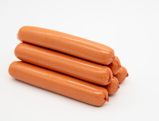 Fresh sausages lie in a pile on a white background.