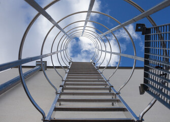 Safety metal ladder to the roof and blue sky, iron staircase