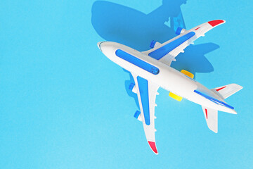 White toy airplane on a sky blue background with space for text. The concept of tourism and travel.