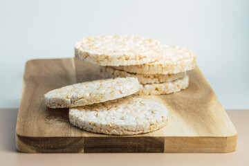 Healthy puffed rice cakes on kitchen wooden board.