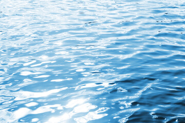 Ripples on lake water. Sunlight reflecting in water. Sun shining by the lake. Ocean wave background. Wavy pond texture. Messy water flow. Blue water surface background. Sky reflection pattern. 