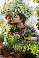 Child helps to father planting herbs and making urban garden