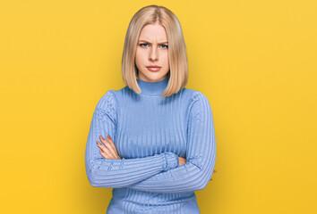 Young blonde woman wearing casual clothes skeptic and nervous, disapproving expression on face with...