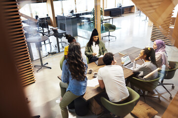 Young businesspeople talking around an office table