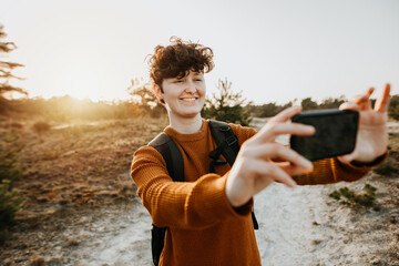 Junge Backpackerin macht ein Selfie in der Natur 