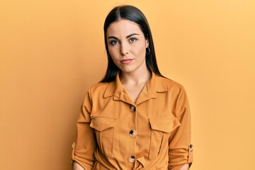 Young brunette woman wearing casual clothes with serious expression on face. simple and natural looking at the camera.