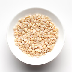 macro Close-up of Organic split polished white urad dal (Vigna mungo) inside a ceramic white bowl. Top view 