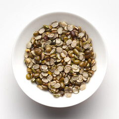 Macro Close-up of Organic split green urad dal (Vigna mungo) inside a ceramic white bowl. Top view 
