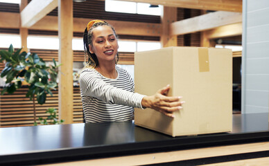 Smiling businesswoman holding a package in an office