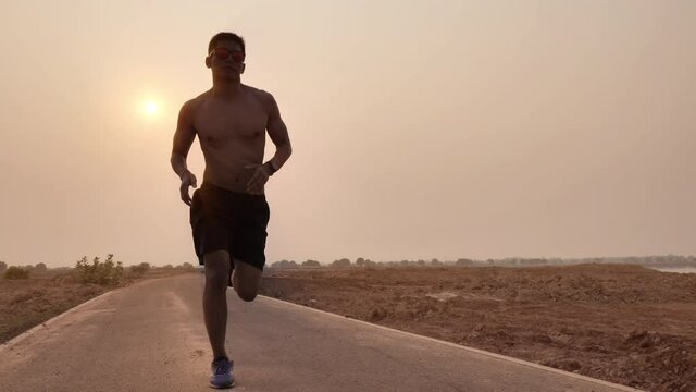 A silhouette of a young man jogging in the evening