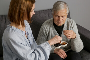 Senior woman having nuts and dried fruits for snack. Healthy dieting and smart snack choice.	