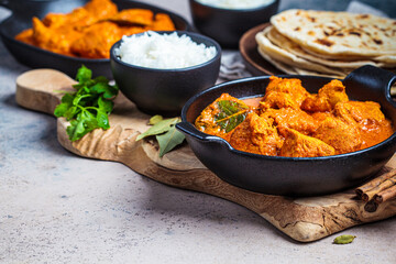 Chicken curry with rice and chapati bread, dark background, copy space. Indian cuisine concept.