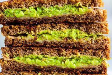 Stack of grilled avocado and cheese sandwiches, close up. Healthy food concept.