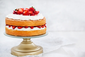 Victoria`s sponge cake, delicious homemade vanilla cake decorated with whipped cream and fresh strawberries