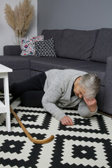 Senior woman lying on the floor in living room. Woman fell on the floor because of heart attack,...