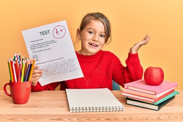 Little beautiful girl showing a passed exam celebrating achievement with happy smile and winner expression with raised hand