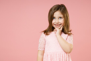 Obraz premium Little kid girl 5-6 years old wears rosy dress look aside up put hand prop up on chin iterates over solution options isolated on pastel pink background child portrait Mother's Day love family concept