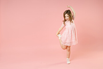 Full length of little kid girl 5-6 years old wears rosy dress have fun dancing fooling around celebrate play isolated on pastel pink background child studio portrait. Mother's Day love family concept.