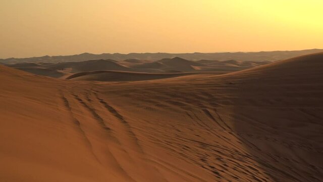 Landscape of desert dunes at sunset on a windy day