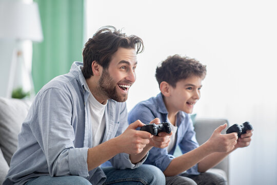 Stay at home with fun. Happy dad and son competing with each other in video games