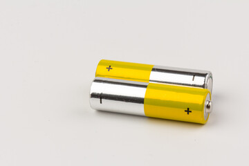 Photo of gray-yellow alkaline AA batteries on white background. Recycling of rechargeable NiMH batteries. The most popular size of accumulators. Copy space.