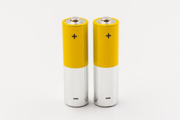 Photo of gray-yellow alkaline AA batteries on white background. Recycling of rechargeable NiMH batteries. The most popular size of accumulators. Copy space.