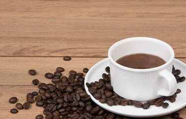 Coffee cup with coffee beans on the wooden background