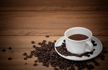 Coffee cup with coffee beans on the wooden background
