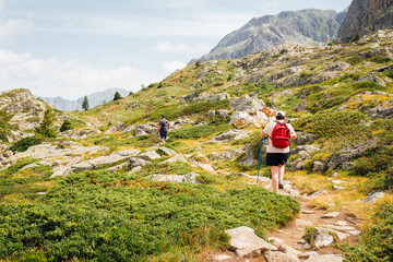 Fototapeta na wymiar un couple de randonneurs dans les Alpes. Des personnes randonnant dans une montagne. Une randonnée en haute montagne. Des gens randonnent au grand air.