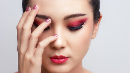 Asian female closeup colorful eyeshadow with extreme long false eyelashes. Eyelash Extensions....