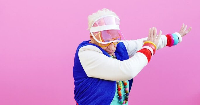 Footage of a funny grandmother with fashionable look acting on colored backgrounds