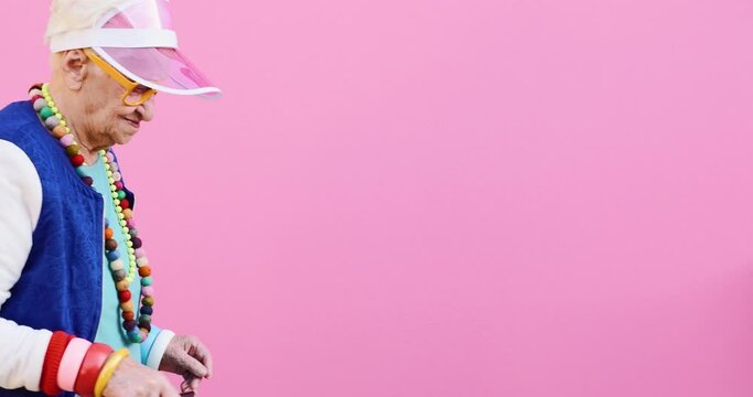 Footage of a funny grandmother with fashionable look acting on colored backgrounds