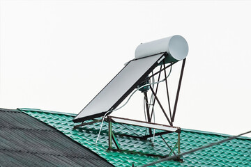 Solar water heater on the roof of a building against the background of the sky. Using solar energy to heat water