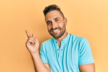 Fototapeta premium Handsome man with beard wearing casual clothes smiling happy pointing with hand and finger to the side