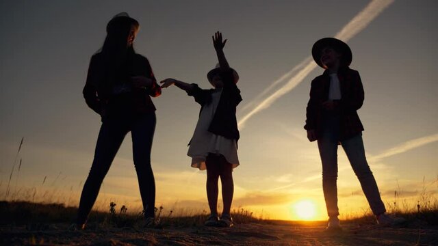 concept of happy children, fun, emotion. teamwork of dancing children in park at sunset. Silhouette of children in park. a group of children dancing at sunset.