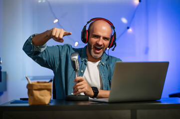 Male blogger working on his channel speaking to camera with a vintage microphone