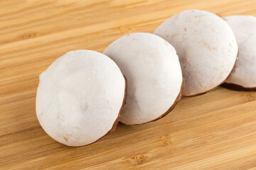 Gingerbread in white glaze with chocolate, on wooden table background. Sweet dissert to tea. Close-up