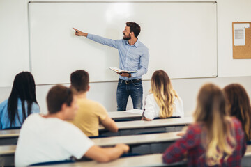 Young students listening to professor in the classroom on college