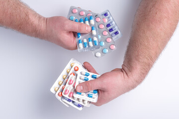 Close-up of hand holding medication blister packs of tablets and capsules against .Colorful pills and medicines in the hand.Medicine and healthcare concept