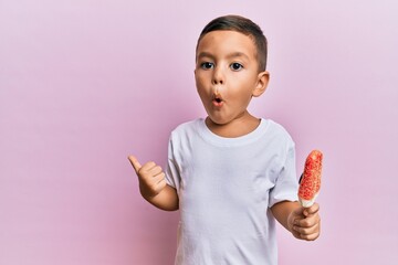 Adorable latin toddler holding ice cream scared and amazed with open mouth for surprise, disbelief...