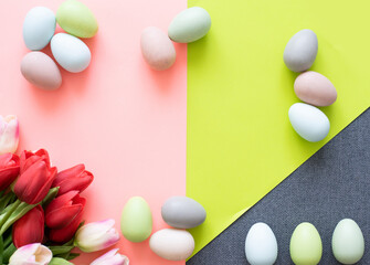 Easter eggs and tulips on light green background